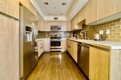 a kitchen with wooden floors and stainless steel appliances at Western Melrose in Los Angeles