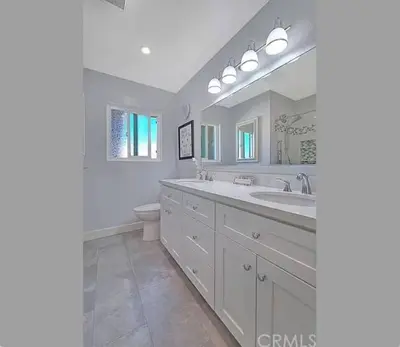 a white bathroom with a sink and a toilet at Mountain View • Pool House in Chino Hills