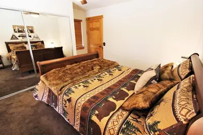 a bedroom with a bed with a dog laying on it at Take a Break in Big Bear Lake