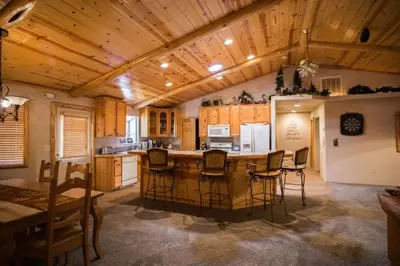 a kitchen with a wooden ceiling and a table and chairs at Luxury w Spa Foosball Near Summit - DeCarlo House in Big Bear Lake