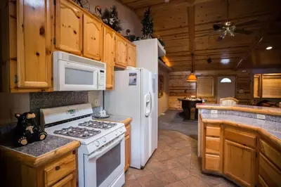 a kitchen with white appliances and wooden cabinets at Luxury w Spa Foosball Near Summit - DeCarlo House in Big Bear Lake