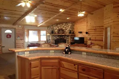 a kitchen with a bar in a log cabin at Luxury w Spa Foosball Near Summit - DeCarlo House in Big Bear Lake
