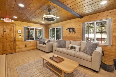 a living room with a couch and a table at Lily's Bear Cabin -Adorable Downtown Retreat Cottage in Big Bear Lake
