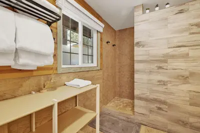a bathroom with a shower with a sink and a window at Lily's Bear Cabin -Adorable Downtown Retreat Cottage in Big Bear Lake