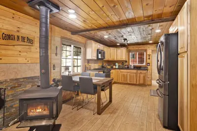 a kitchen with a stove and a table in a room at Lily's Bear Cabin -Adorable Downtown Retreat Cottage in Big Bear Lake