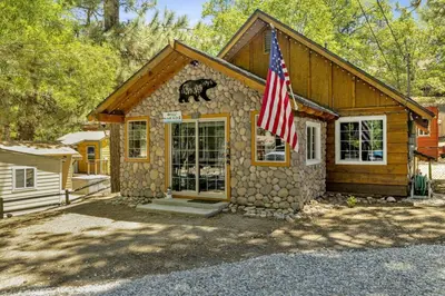 a house with a flag in front of it at Lily's Bear Cabin -Adorable Downtown Retreat Cottage in Big Bear Lake