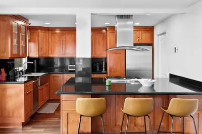 a kitchen with wooden cabinets and a black counter top at Spectacular Views and Tranquil Retreat in Los Feliz in Los Angeles