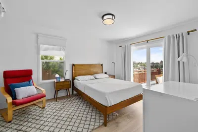 a bedroom with a bed and a red chair at Spectacular Views and Tranquil Retreat in Los Feliz in Los Angeles