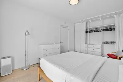 a white bedroom with a white bed and white cabinets at Spectacular Views and Tranquil Retreat in Los Feliz in Los Angeles