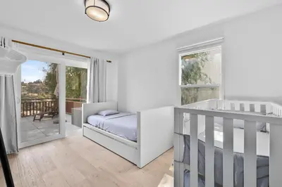 a white bedroom with a bed and a balcony at Spectacular Views and Tranquil Retreat in Los Feliz in Los Angeles