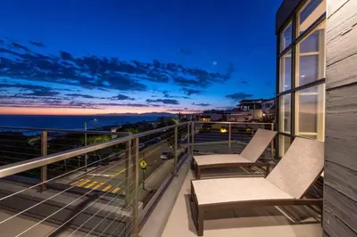 a balcony with two chairs and a view of the ocean at Stunning Panoramic Ocean Views Penthouse Hot Tub in Manhattan Beach