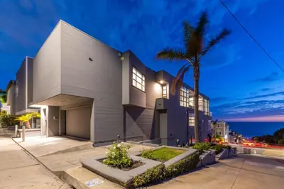 a house with a palm tree in front of it at Stunning Panoramic Ocean Views Penthouse Hot Tub in Manhattan Beach