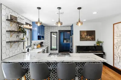 a kitchen with a large white counter and chairs at Charming 2BR in Heart of LA with Spacious Backyard in Los Angeles