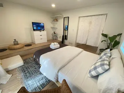 a bedroom with a large white bed and a television at Private and Quiet Los Feliz Guest Suite with VIEWS in Los Angeles