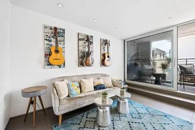 a living room with a couch and instruments on the wall at The Blue Wave - 3 blocks from Manhattan Beach Pier in Manhattan Beach