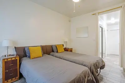 a bedroom with two beds with yellow pillows at Westwood UCLA 2BR, 1BA Cozy Condo w Amenities in Los Angeles