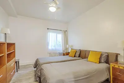 a bedroom with a bed and a couch with yellow pillows at Westwood UCLA 2BR, 1BA Cozy Condo w Amenities in Los Angeles