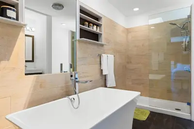 a bathroom with a white sink and a shower at Hilltop Designer Midcentury Modern 4BR Pool HotTub in Los Angeles