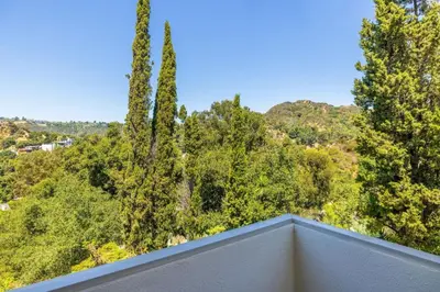 a view from the balcony of a house with trees at Hilltop Designer Midcentury Modern 4BR Pool HotTub in Los Angeles