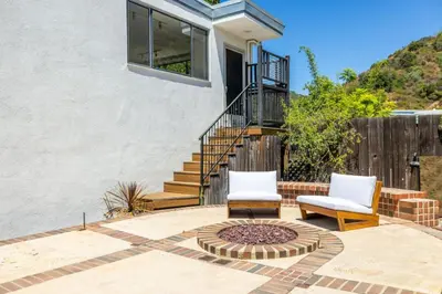 two chairs and a fire pit in front of a house at Hilltop Designer Midcentury Modern 4BR Pool HotTub in Los Angeles