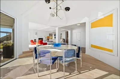 a dining room with a glass table and blue chairs at Luxe Malibu Retreat - Ocean Views, Hot Tub and Gym in Malibu
