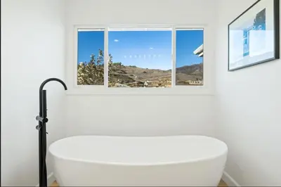 a bathroom with a white tub and a window at Luxe Malibu Retreat - Ocean Views, Hot Tub and Gym in Malibu