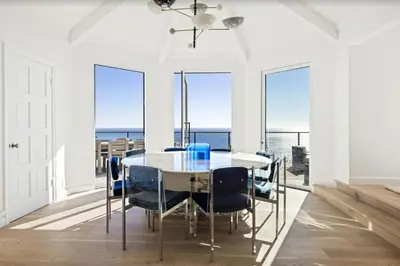 a dining room with a table and chairs and the ocean at Luxe Malibu Retreat - Ocean Views, Hot Tub and Gym in Malibu