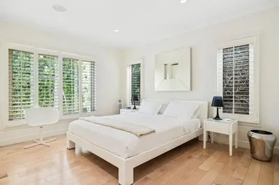 a white bedroom with a large bed and a mirror at Private Designer Home in West Hollywood in Los Angeles