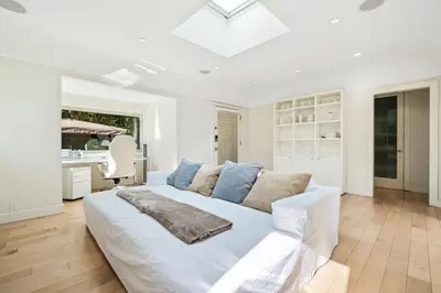 a white bedroom with a large bed and a kitchen at Private Designer Home in West Hollywood in Los Angeles