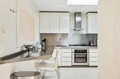 a kitchen with white cabinets and a stove at Private Designer Home in West Hollywood in Los Angeles