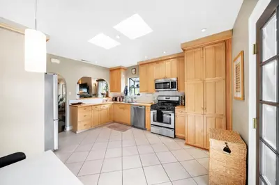 a kitchen with wooden cabinets and stainless steel appliances at Atwater Oasis with Pool and HotTub very Walkable Area in Glendale