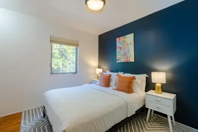 a bedroom with a large bed with a blue wall at Heart of Venice Designer Home Near Abbot Kinney in Los Angeles
