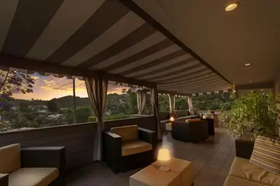 a rooftop patio with couches and tables and a view at Hollywood Dell Oasis, Canyon VIEWS, Fire Pit and BBQ in Los Angeles