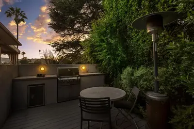 a table and chairs on a deck with a bar at Hollywood Dell Oasis, Canyon VIEWS, Fire Pit and BBQ in Los Angeles