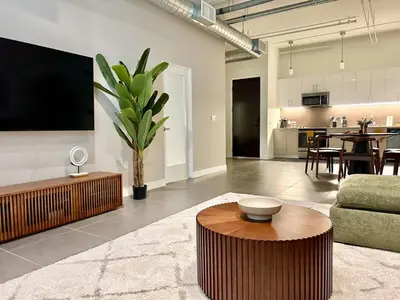 a living room with a couch and a table at DTLA 2BR Loft with Hot Tub & Rooftop Pool! in Los Angeles