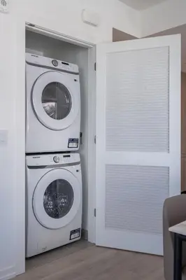 a laundry room with a washer and dryer next to a door at Level Olympic in Los Angeles