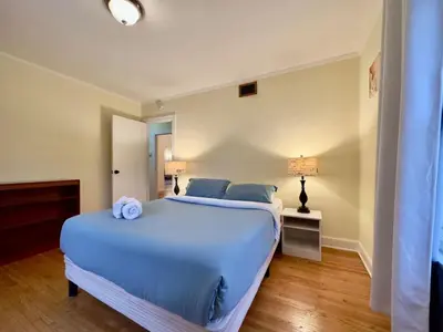a bedroom with a large bed with blue pillows at Tranquil Comfortable 2BR Home Mid Wilshire in Los Angeles