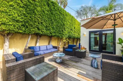 a patio with blue furniture and an umbrella at Spanish Bungalow in Trendy Los Feliz For Families in Los Angeles