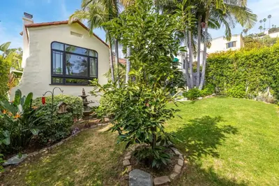 a small house with a tree in the yard at Spanish Bungalow in Trendy Los Feliz For Families in Los Angeles