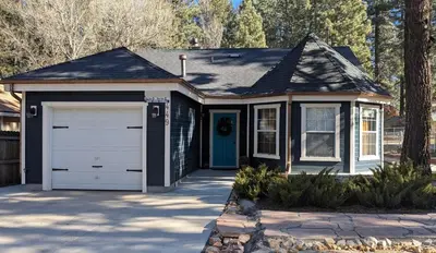 a small house with a garage and a driveway at The Quiz Cottage Games & BBQ Outdoor Area! in Big Bear Lake