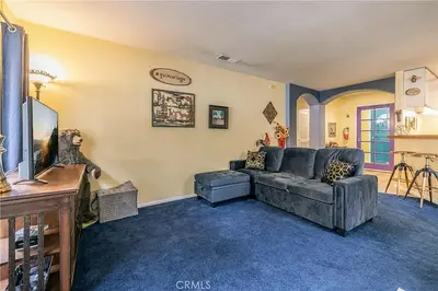 a living room with a couch and a tv at The Quiz Cottage Games & BBQ Outdoor Area! in Big Bear Lake