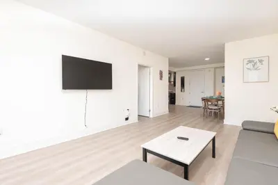 a living room with a couch and a tv on a wall at Skyline Suites in North Hollywood