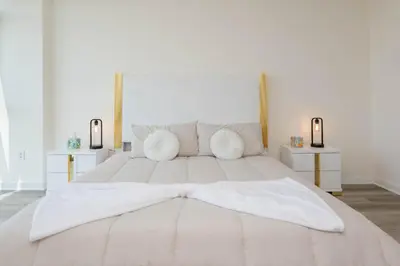 a bedroom with a large white bed with two night stands at Skyline Suites in North Hollywood