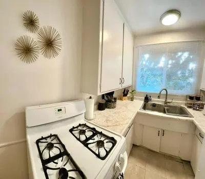 a white kitchen with a stove and a sink at Cozy home in Franklin Village, Central location! in Los Angeles