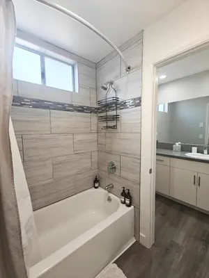 a bathroom with a white tub and a sink at Skyline Escape 1-Bedroom with Balcony and Roof-Top Pool in Los Angeles