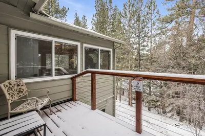 a porch with a chair and a sign on it at Sueños Azules- Fawnskin Retreat Cottage in Big Bear in Fawnskin
