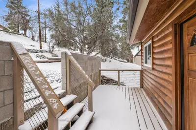 a snowy stairway leading to a door of a house at Sueños Azules- Fawnskin Retreat Cottage in Big Bear in Fawnskin