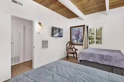 a bedroom with two beds and a window at Sueños Azules- Fawnskin Retreat Cottage in Big Bear in Fawnskin