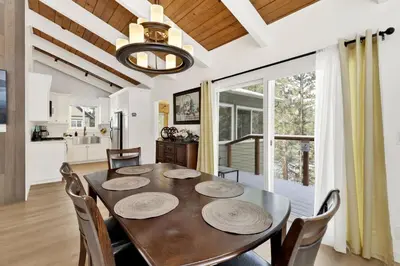 a dining room with a table and chairs and a kitchen at Sueños Azules- Fawnskin Retreat Cottage in Big Bear in Fawnskin