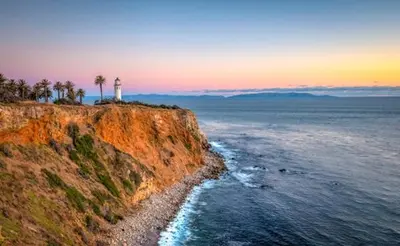 a lighthouse on a cliff with palm trees and the ocean at LA Coastal Oasis in Rancho Palos Verdes
